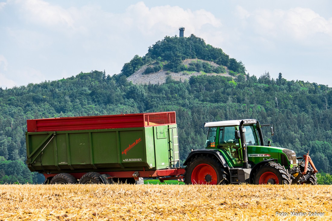 Foto: Martin Zehrer - Erntezeit: Ein FENDT 718 mit vollgeladenem Kipper, im Hintergrund der Rauhe Kulm. 