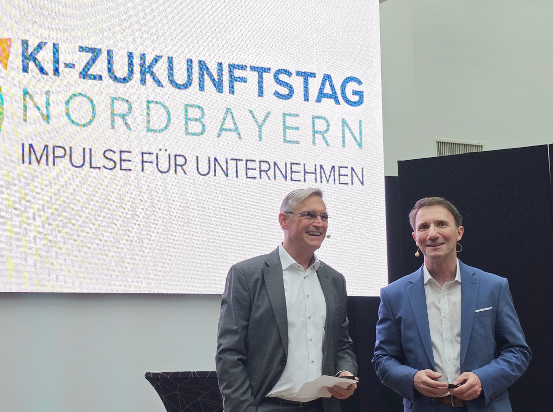 Herzliche Vorstellung von Michael Hampel durch Dr. Michael Hohl

Mit einer warmen und wertschätzenden Ansprache begrüßte Dr. Michael Hohl den nächsten Referenten auf der Bühne des KI-Zukunftstags in Bayreuth. Dabei stellte er Michael Hampel dem Publikum vor und hob dessen umfangreiche Erfahrung in der Begleitung von Unternehmen durch Veränderungsprozesse hervor.

Dr. Hohl betonte insbesondere die Bedeutung des menschlichen Faktors bei der Einführung von Künstlicher Intelligenz und schlug damit die inhaltliche Brücke zum anschließenden Vortrag "Dream-Team Mensch und KI?". Mit seinen Worten machte er deutlich, dass technologische Innovation nur dann ihr volles Potenzial entfalten kann, wenn sie von den Menschen im Unternehmen getragen wird.

Die herzliche Vorstellung sorgte für eine offene und positive Atmosphäre im Saal und bereitete den idealen Einstieg in den folgenden Vortrag. Das Publikum wurde so nicht nur inhaltlich abgeholt, sondern auch persönlich auf den Referenten eingestimmt.