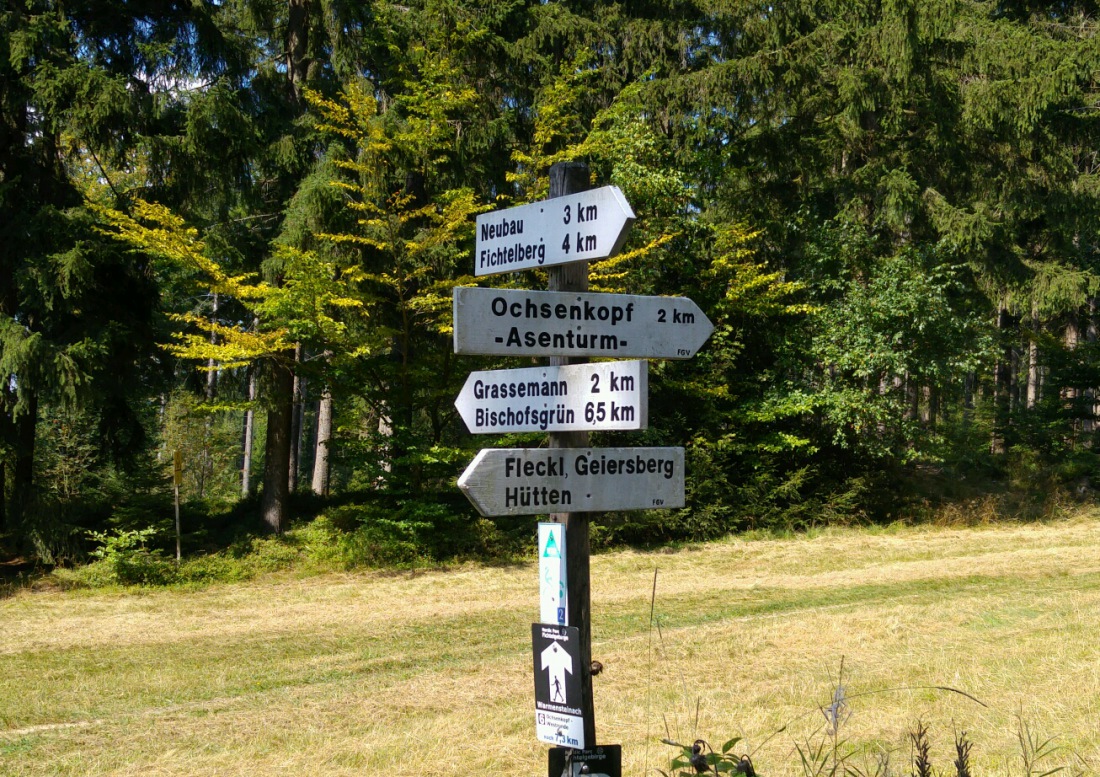 Foto: Martin Zehrer - Ziemlich weit unten, am Fuße des Ochsenkopfes, steht dieser Wegweiser. Nur noch ca. 2 Kilometer bergauf treten und schon sind wir auf dem Gipfel... ;-) 