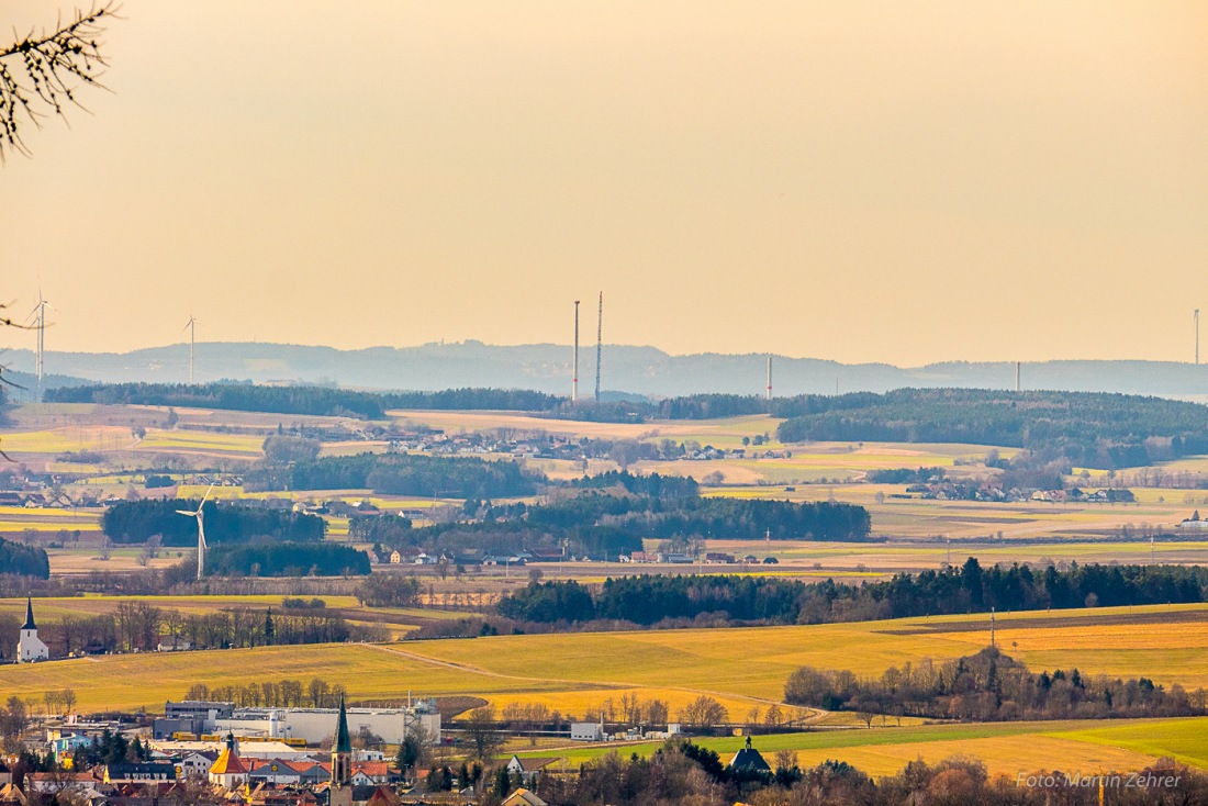 Foto: Martin Zehrer - Im Vordergrund der kemnather Kirchturm, links die Kirche von Oberndorf und im Hintergrund sieht man ein unfertiges Windrad nebst riesigen Aufbau-Kran. 