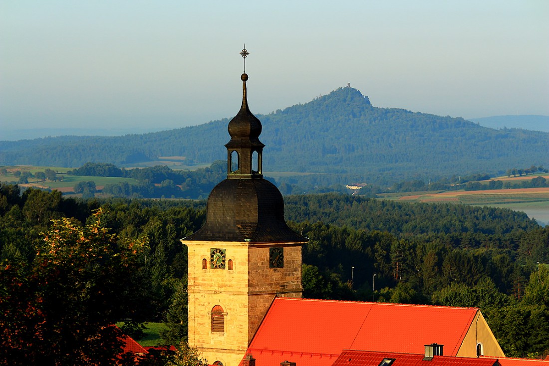 Foto: Martin Zehrer - Die Waldecker Kirche St. Johannes Nepomuk vor dem Vulkankegel Rauher Kulm bei Neustadt am Kulm  