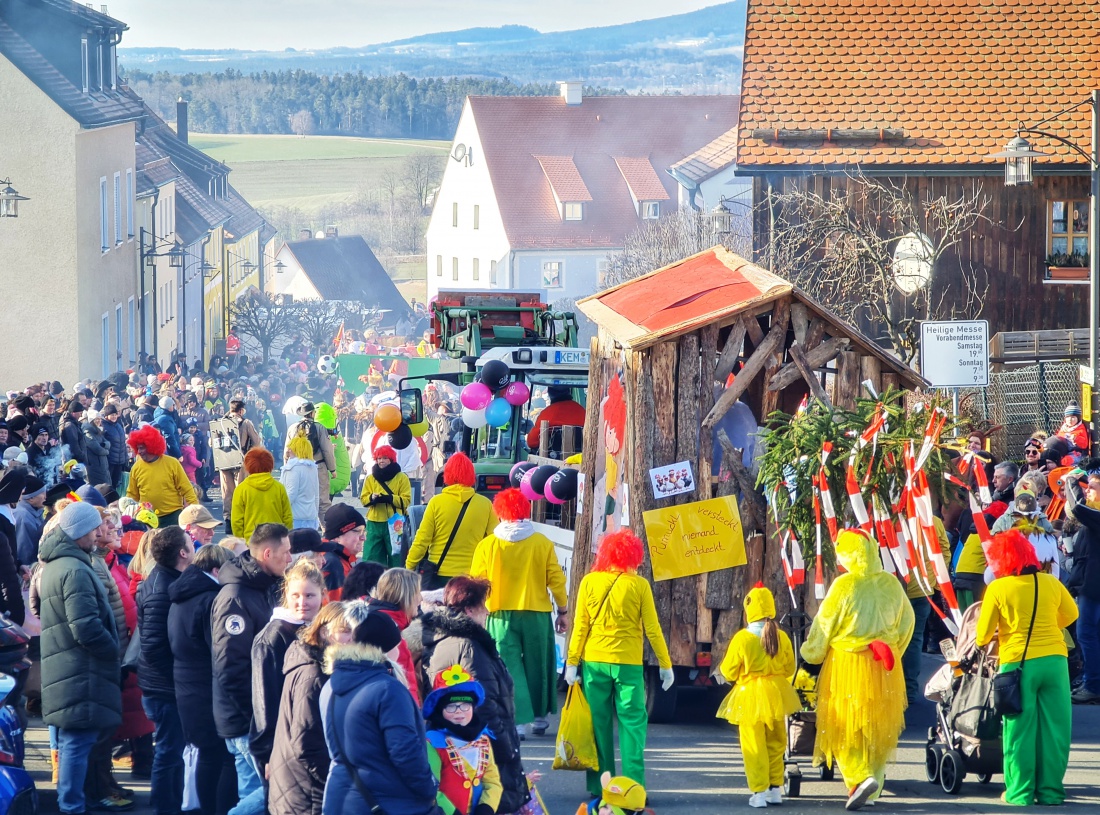 Kaiserwetter beim legendären Faschingszug in Waldeck. Die Hauptstraße ist gesäumt von vielen fröhlichen Menschen, die alle die wunderbaren Kostüme und Umzugswagen der verschiedenen Vereine und Gruppen bewundern. 