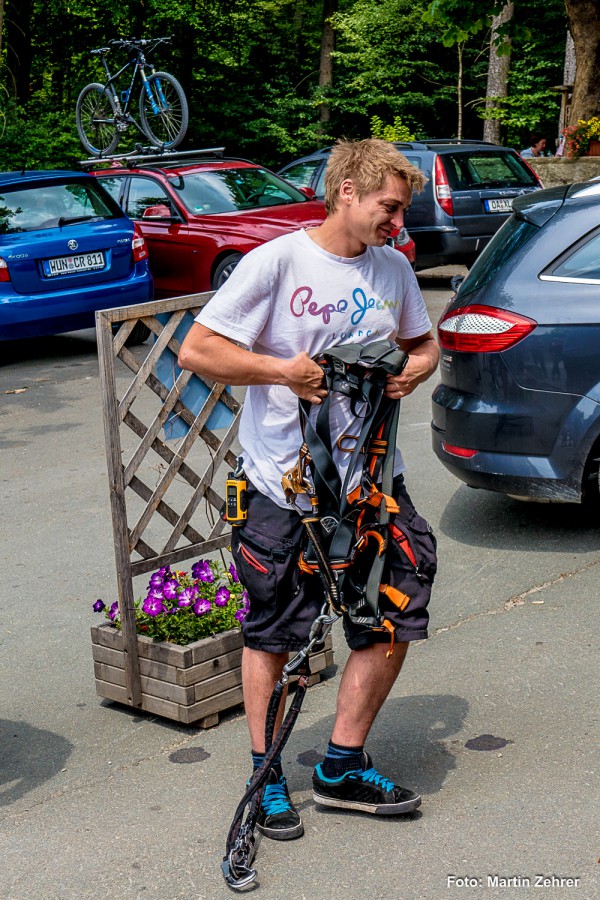 Foto: Martin Zehrer - Der Zipline-Guide zeigt, wie man in das Gurtzeug einsteigt. Zugleich schaut er genau hin, ob das Gurtanlegen bei den Teilnehmern richtig funktioniert. 