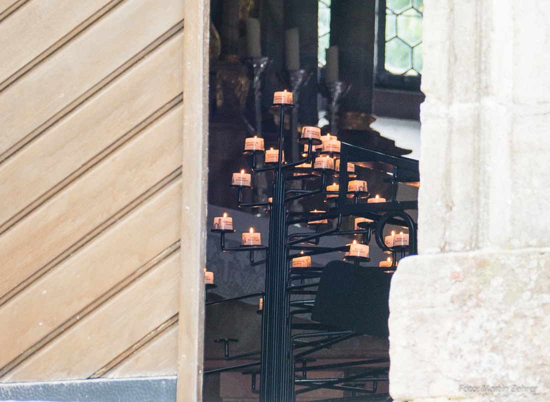 Foto: Martin Zehrer - Armesberg: Angezündete Kerzen, gesehen durch den Blick in die Kirche. Es ist Brauch, beim Entzünden der Kerzen einen Wunsch bzw. eine Bitte auszusprechen... 