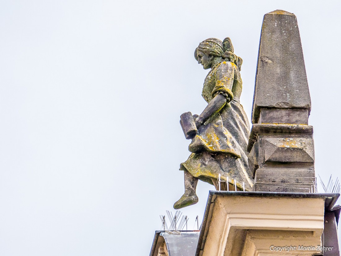 Foto: Martin Zehrer - Nur noch einen kleinen Schritt - Dann liegt sie unten... Wie fein doch damals das Gesicht gearbeitet wurde, obwohl die Dame mit ihren Maßkrügen ca. 12 Meter über dem Bode 