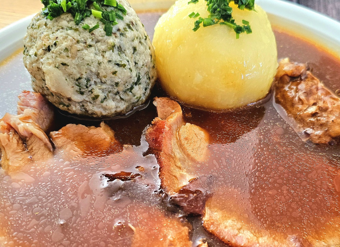 Herzhafter Schweinebraten in der Gaststätte Schmid in Tremmersdorf

Wer die traditionelle Oberpfälzer Küche schätzt, kommt in der Gaststätte Schmid in Tremmersdorf auf seine Kosten. Der saftige Schweinebraten mit knuspriger Kruste wird zusammen mit einem klassischen Kartoffelknödel, einem hausgemachten Semmelknödel und einer kräftigen Bratensoße serviert – ein Gericht, das seit Generationen zu den beliebtesten Spezialitäten der Region zählt.