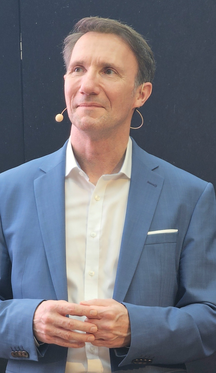 Michael Hampel: Mensch und KI als erfolgreiches Zusammenspiel

Mit seinem Vortrag "Dream-Team Mensch und KI?" zeigte Michael Hampel auf dem KI-Zukunftstag in Bayreuth eindrucksvoll, dass der erfolgreiche Einsatz von Künstlicher Intelligenz weit über die Technologie hinausgeht.

Im Mittelpunkt seines Beitrags stand der Mensch als entscheidender Erfolgsfaktor. Hampel machte deutlich, dass Unternehmen ihre Mitarbeitenden aktiv in den Veränderungsprozess einbinden müssen, um das volle Potenzial von KI ausschöpfen zu können. Dabei ging es nicht nur um technische Fähigkeiten, sondern vor allem um Akzeptanz, Verständnis und die Bereitschaft, neue Wege zu gehen.

Anhand praxisnaher Beispiele zeigte er, wie Unternehmen ihre Teams für den Einsatz von KI begeistern und den Wandel strukturiert gestalten können. Besonders im Fokus standen dabei konkrete Ansätze für einen erfolgreichen Change-Prozess sowie die produktive Nutzung von KI im Arbeitsalltag.

Die Teilnehmenden profitierten von klaren Handlungsempfehlungen und direkt umsetzbaren Impulsen. Der Vortrag machte deutlich, dass Mensch und KI kein Gegensatz sind, sondern gemeinsam ein starkes Team bilden können - vorausgesetzt, der Wandel wird aktiv und bewusst gestaltet.