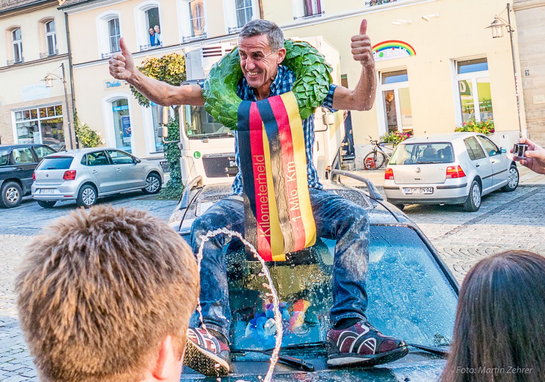 Foto: Martin Zehrer - So sehen Sieger aus - Helmut sitzt auf seinem Opel Astra und reißt die Hände hoch. Die 1.000.000 Kilometer sind geknackt und der Kilometerzähler ist nach 999.999 wieder a 
