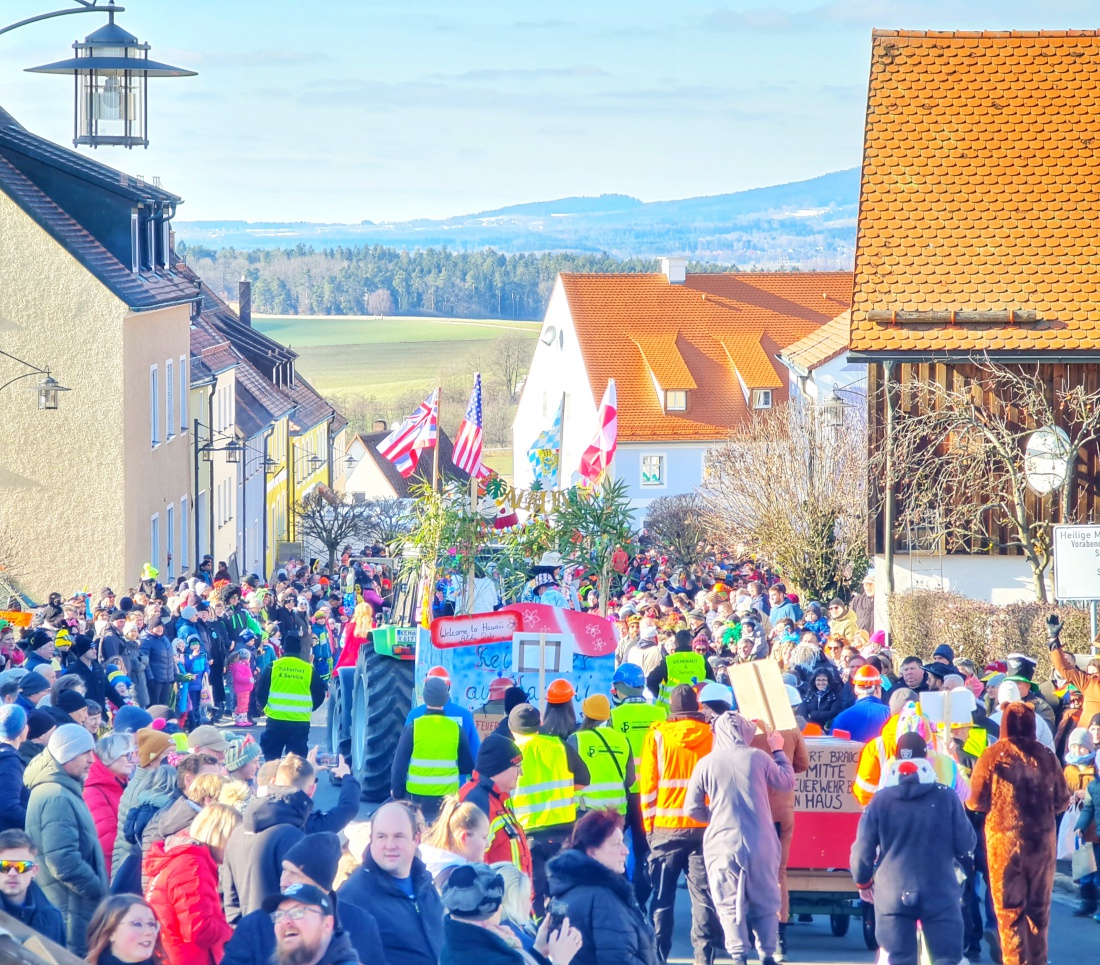 Kaiserwetter beim legendären Faschingszug in Waldeck. Die Hauptstraße ist gesäumt von vielen fröhlichen Menschen, die alle die wunderbaren Kostüme und Umzugswagen der verschiedenen Vereine und Gruppen bewundern. 