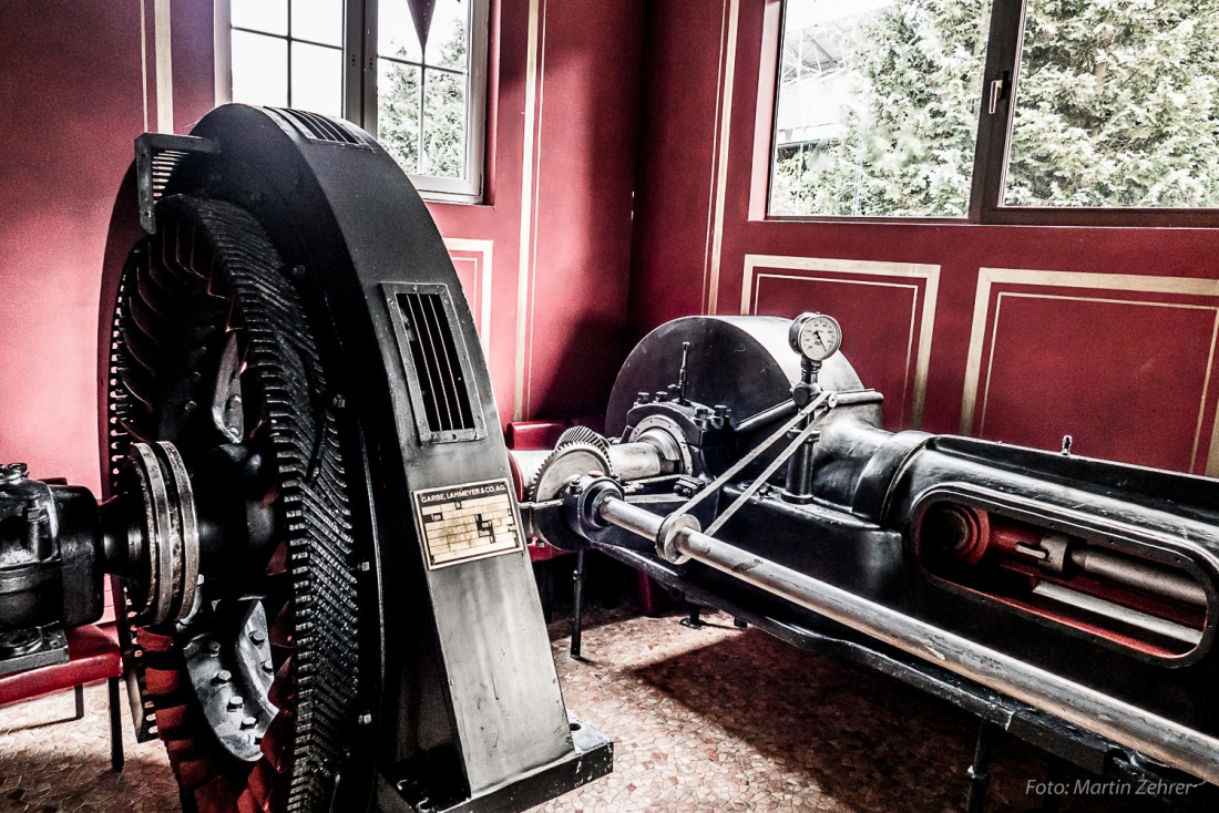 Foto: Martin Zehrer - Hier erkennt man den Generator mit der Kurbelwelle der Dampfmaschine verbunden. Gesehen im Restaurant Museo in Fichtelberg. Auch ein großes Schwungrad war noch angebracht 