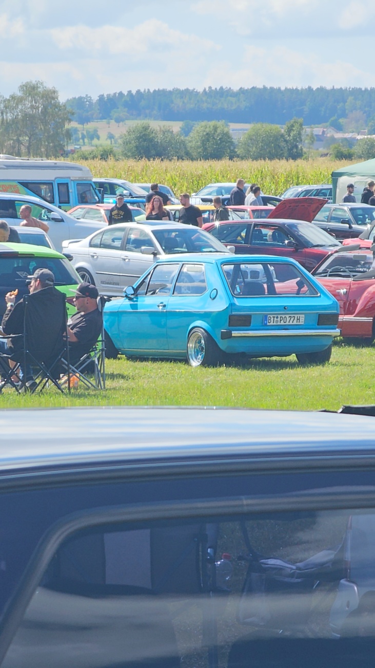 Am Sonntag, 23. August 2026, verwandelte sich der Flugplatz Rosenthal Airfield in Speichersdorf wieder in einen großen Treffpunkt für Fahrzeugfans. Bei „Performance On Wheels – Stage IX“ standen Fahrzeuge unterschiedlichster Art und Baujahre im Mittelpunkt. Bereits zum neunten Mal fand das markenoffene Treffen auf dem weitläufigen Flugplatzgelände statt.
Schon beim Rundgang zeigte sich die enorme Vielfalt: Oldtimer, US-Cars, Motorräder, aufwendig umgebaute Tuningfahrzeuge, Supersportwagen und Lastwagen standen teilweise unmittelbar nebeneinander. Vom liebevoll erhaltenen Klassiker bis zum modernen Fahrzeug mit auffälligen Umbauten gab es für die Besucher jede Menge zu entdecken und natürlich auch zahlreiche interessante Fotomotive.