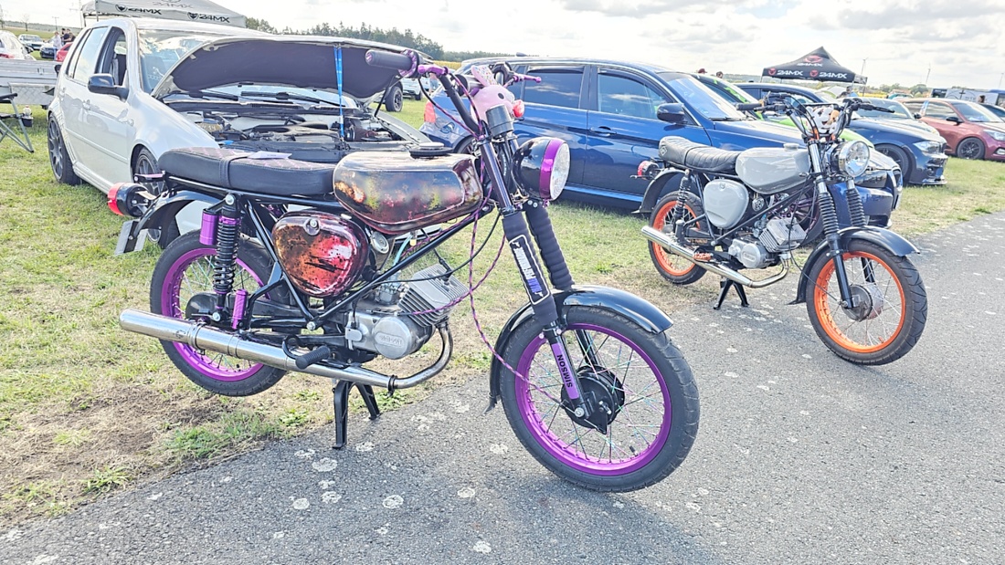 Am Sonntag, 23. August 2026, verwandelte sich der Flugplatz Rosenthal Airfield in Speichersdorf wieder in einen großen Treffpunkt für Fahrzeugfans. Bei „Performance On Wheels – Stage IX“ standen Fahrzeuge unterschiedlichster Art und Baujahre im Mittelpunkt. Bereits zum neunten Mal fand das markenoffene Treffen auf dem weitläufigen Flugplatzgelände statt.
Schon beim Rundgang zeigte sich die enorme Vielfalt: Oldtimer, US-Cars, Motorräder, aufwendig umgebaute Tuningfahrzeuge, Supersportwagen und Lastwagen standen teilweise unmittelbar nebeneinander. Vom liebevoll erhaltenen Klassiker bis zum modernen Fahrzeug mit auffälligen Umbauten gab es für die Besucher jede Menge zu entdecken und natürlich auch zahlreiche interessante Fotomotive.