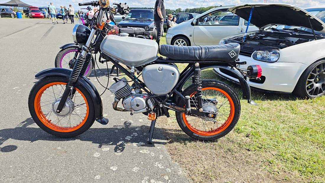 Am Sonntag, 23. August 2026, verwandelte sich der Flugplatz Rosenthal Airfield in Speichersdorf wieder in einen großen Treffpunkt für Fahrzeugfans. Bei „Performance On Wheels – Stage IX“ standen Fahrzeuge unterschiedlichster Art und Baujahre im Mittelpunkt. Bereits zum neunten Mal fand das markenoffene Treffen auf dem weitläufigen Flugplatzgelände statt.
Schon beim Rundgang zeigte sich die enorme Vielfalt: Oldtimer, US-Cars, Motorräder, aufwendig umgebaute Tuningfahrzeuge, Supersportwagen und Lastwagen standen teilweise unmittelbar nebeneinander. Vom liebevoll erhaltenen Klassiker bis zum modernen Fahrzeug mit auffälligen Umbauten gab es für die Besucher jede Menge zu entdecken und natürlich auch zahlreiche interessante Fotomotive.