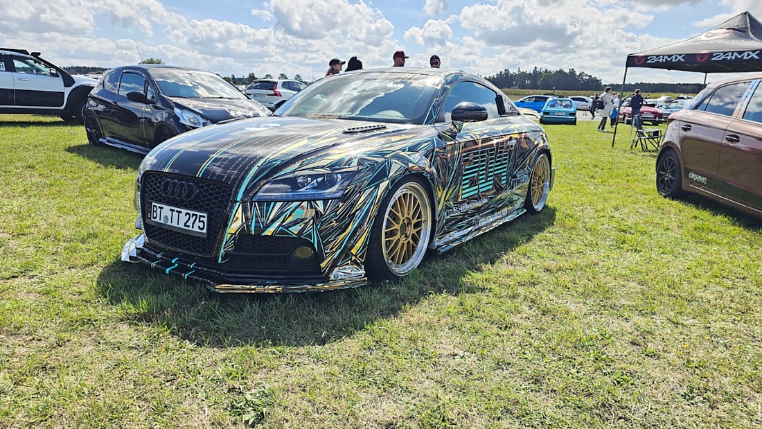 Am Sonntag, 23. August 2026, verwandelte sich der Flugplatz Rosenthal Airfield in Speichersdorf wieder in einen großen Treffpunkt für Fahrzeugfans. Bei „Performance On Wheels – Stage IX“ standen Fahrzeuge unterschiedlichster Art und Baujahre im Mittelpunkt. Bereits zum neunten Mal fand das markenoffene Treffen auf dem weitläufigen Flugplatzgelände statt.
Schon beim Rundgang zeigte sich die enorme Vielfalt: Oldtimer, US-Cars, Motorräder, aufwendig umgebaute Tuningfahrzeuge, Supersportwagen und Lastwagen standen teilweise unmittelbar nebeneinander. Vom liebevoll erhaltenen Klassiker bis zum modernen Fahrzeug mit auffälligen Umbauten gab es für die Besucher jede Menge zu entdecken und natürlich auch zahlreiche interessante Fotomotive.