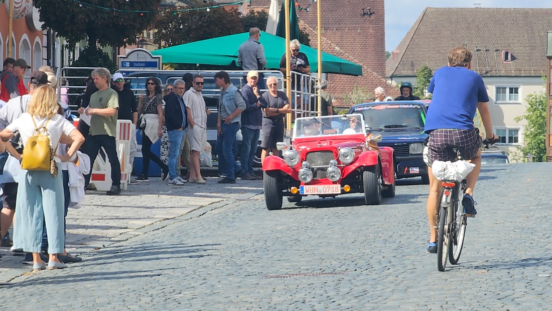 Jede Menge automobile Schätze auf dem Kemnather Stadtplatz

Ein echtes Paradies für Oldtimerfreunde gab es am Samstag beim großen Oldtimertreffen in Kemnath zu erleben. Ab 10 Uhr gehörte der wunderschöne historische Stadtplatz den automobilen Schätzen vergangener Jahrzehnte. Bei bestem Oldtimerwetter präsentierten sich die liebevoll gepflegten Fahrzeuge vor einer traumhaften Kulisse – und natürlich ließen sich das auch jede Menge Zuschauer nicht entgehen.

Dicht an dicht standen die Besucher entlang des Stadtplatzes, als ein Klassiker nach dem anderen zur Fahrzeugvorstellung vorfuhr. Dabei gab es nicht nur jede Menge Chrom, glänzenden Lack und den unverwechselbaren Klang alter Motoren zu bestaunen, sondern auch viel Wissenswertes zu hören.

Wie jedes Jahr hatte Elmar Högl das Mikrofon fest im Griff. Souverän und mit enormem Fachwissen stellte er die einzelnen Fahrzeuge vor, erzählte von Baujahren, Motorisierung und technischen Besonderheiten und hatte dabei immer wieder interessante Details zu den Oldtimern parat.

Und eigentlich ist Elmar Högl aus dem Kemnather Oldtimertreffen kaum wegzudenken. Er ist nicht nur die bekannte Stimme am Mikrofon, sondern zugleich Hauptorganisator und so etwas wie das „Herz“ des Treffens. Gemeinsam mit dem KEM-Verband und der Stadt Kemnath sorgt er dafür, dass die Freunde historischer Fahrzeuge Jahr für Jahr in Kemnath zusammenkommen.

Zur Fahrzeugvorstellung gehörte natürlich auch die Übergabe der Urkunden. Diese Aufgabe übernahm Hermann Schraml, unterstützt von Stefan Wöhrl.

Und besser hätte es an diesem Vormittag eigentlich kaum passen können: herrliches Wetter, ein voller Stadtplatz, viele begeisterte Zuschauer und mittendrin jede Menge automobile Zeitgeschichte auf zwei und vier Rädern.

Nach der Vorstellung blieb noch genügend Zeit, die Oldtimer aus nächster Nähe zu betrachten, mit den Besitzern ins Gespräch zu kommen und natürlich jede Menge Fotos zu machen.

Am Nachmittag wartete dann bereits der nächste Höhepunkt auf die Teilnehmer. Um 13:15 Uhr machten sich die historischen Fahrzeuge zur gemeinsamen Ausfahrt auf den Weg. Über Berndorf, Haidenaab und Weidenberg führte die Tour unter anderem nach Goldkronach, wo eine längere Rast eingelegt wurde, bevor es schließlich wieder zurück nach Kemnath ging.

Und jetzt viel Spaß beim Durchklicken durch unsere Bilder vom Kemnather Oldtimertreffen 2026!