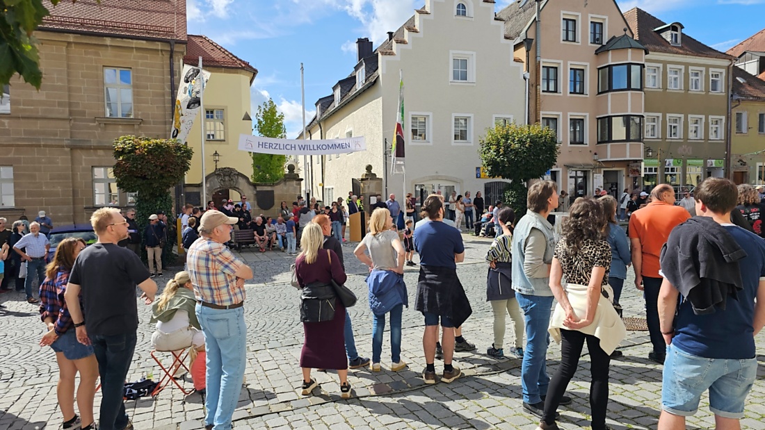 Jede Menge automobile Schätze auf dem Kemnather Stadtplatz

Ein echtes Paradies für Oldtimerfreunde gab es am Samstag beim großen Oldtimertreffen in Kemnath zu erleben. Ab 10 Uhr gehörte der wunderschöne historische Stadtplatz den automobilen Schätzen vergangener Jahrzehnte. Bei bestem Oldtimerwetter präsentierten sich die liebevoll gepflegten Fahrzeuge vor einer traumhaften Kulisse – und natürlich ließen sich das auch jede Menge Zuschauer nicht entgehen.

Dicht an dicht standen die Besucher entlang des Stadtplatzes, als ein Klassiker nach dem anderen zur Fahrzeugvorstellung vorfuhr. Dabei gab es nicht nur jede Menge Chrom, glänzenden Lack und den unverwechselbaren Klang alter Motoren zu bestaunen, sondern auch viel Wissenswertes zu hören.

Wie jedes Jahr hatte Elmar Högl das Mikrofon fest im Griff. Souverän und mit enormem Fachwissen stellte er die einzelnen Fahrzeuge vor, erzählte von Baujahren, Motorisierung und technischen Besonderheiten und hatte dabei immer wieder interessante Details zu den Oldtimern parat.

Und eigentlich ist Elmar Högl aus dem Kemnather Oldtimertreffen kaum wegzudenken. Er ist nicht nur die bekannte Stimme am Mikrofon, sondern zugleich Hauptorganisator und so etwas wie das „Herz“ des Treffens. Gemeinsam mit dem KEM-Verband und der Stadt Kemnath sorgt er dafür, dass die Freunde historischer Fahrzeuge Jahr für Jahr in Kemnath zusammenkommen.

Zur Fahrzeugvorstellung gehörte natürlich auch die Übergabe der Urkunden. Diese Aufgabe übernahm Hermann Schraml, unterstützt von Stefan Wöhrl.

Und besser hätte es an diesem Vormittag eigentlich kaum passen können: herrliches Wetter, ein voller Stadtplatz, viele begeisterte Zuschauer und mittendrin jede Menge automobile Zeitgeschichte auf zwei und vier Rädern.

Nach der Vorstellung blieb noch genügend Zeit, die Oldtimer aus nächster Nähe zu betrachten, mit den Besitzern ins Gespräch zu kommen und natürlich jede Menge Fotos zu machen.

Am Nachmittag wartete dann bereits der nächste Höhepunkt auf die Teilnehmer. Um 13:15 Uhr machten sich die historischen Fahrzeuge zur gemeinsamen Ausfahrt auf den Weg. Über Berndorf, Haidenaab und Weidenberg führte die Tour unter anderem nach Goldkronach, wo eine längere Rast eingelegt wurde, bevor es schließlich wieder zurück nach Kemnath ging.

Und jetzt viel Spaß beim Durchklicken durch unsere Bilder vom Kemnather Oldtimertreffen 2026!