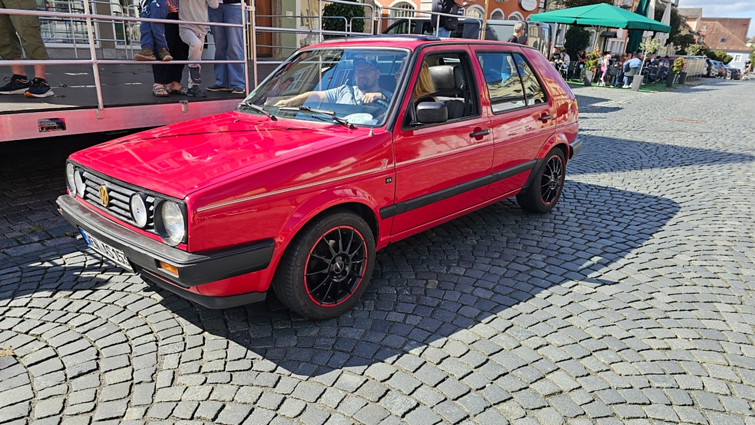 Jede Menge automobile Schätze auf dem Kemnather Stadtplatz

Ein echtes Paradies für Oldtimerfreunde gab es am Samstag beim großen Oldtimertreffen in Kemnath zu erleben. Ab 10 Uhr gehörte der wunderschöne historische Stadtplatz den automobilen Schätzen vergangener Jahrzehnte. Bei bestem Oldtimerwetter präsentierten sich die liebevoll gepflegten Fahrzeuge vor einer traumhaften Kulisse – und natürlich ließen sich das auch jede Menge Zuschauer nicht entgehen.

Dicht an dicht standen die Besucher entlang des Stadtplatzes, als ein Klassiker nach dem anderen zur Fahrzeugvorstellung vorfuhr. Dabei gab es nicht nur jede Menge Chrom, glänzenden Lack und den unverwechselbaren Klang alter Motoren zu bestaunen, sondern auch viel Wissenswertes zu hören.

Wie jedes Jahr hatte Elmar Högl das Mikrofon fest im Griff. Souverän und mit enormem Fachwissen stellte er die einzelnen Fahrzeuge vor, erzählte von Baujahren, Motorisierung und technischen Besonderheiten und hatte dabei immer wieder interessante Details zu den Oldtimern parat.

Und eigentlich ist Elmar Högl aus dem Kemnather Oldtimertreffen kaum wegzudenken. Er ist nicht nur die bekannte Stimme am Mikrofon, sondern zugleich Hauptorganisator und so etwas wie das „Herz“ des Treffens. Gemeinsam mit dem KEM-Verband und der Stadt Kemnath sorgt er dafür, dass die Freunde historischer Fahrzeuge Jahr für Jahr in Kemnath zusammenkommen.

Zur Fahrzeugvorstellung gehörte natürlich auch die Übergabe der Urkunden. Diese Aufgabe übernahm Hermann Schraml, unterstützt von Stefan Wöhrl.

Und besser hätte es an diesem Vormittag eigentlich kaum passen können: herrliches Wetter, ein voller Stadtplatz, viele begeisterte Zuschauer und mittendrin jede Menge automobile Zeitgeschichte auf zwei und vier Rädern.

Nach der Vorstellung blieb noch genügend Zeit, die Oldtimer aus nächster Nähe zu betrachten, mit den Besitzern ins Gespräch zu kommen und natürlich jede Menge Fotos zu machen.

Am Nachmittag wartete dann bereits der nächste Höhepunkt auf die Teilnehmer. Um 13:15 Uhr machten sich die historischen Fahrzeuge zur gemeinsamen Ausfahrt auf den Weg. Über Berndorf, Haidenaab und Weidenberg führte die Tour unter anderem nach Goldkronach, wo eine längere Rast eingelegt wurde, bevor es schließlich wieder zurück nach Kemnath ging.

Und jetzt viel Spaß beim Durchklicken durch unsere Bilder vom Kemnather Oldtimertreffen 2026!
