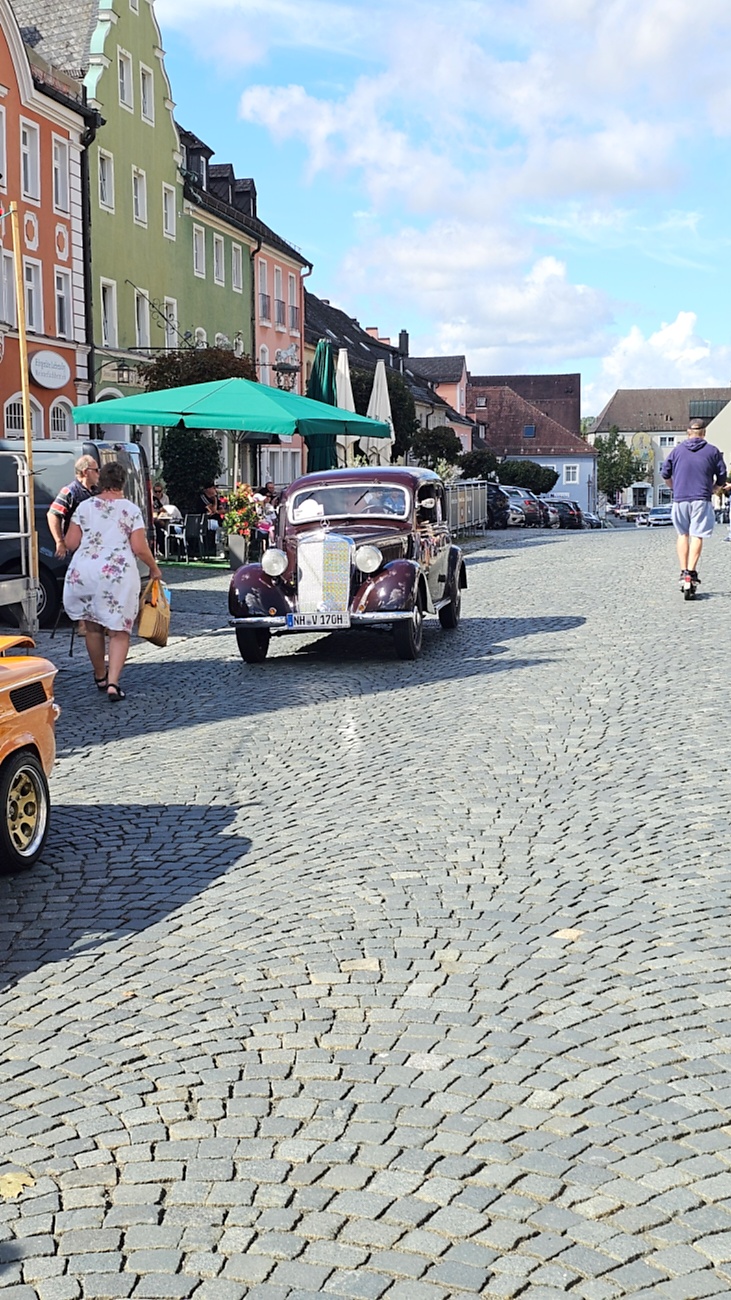 Jede Menge automobile Schätze auf dem Kemnather Stadtplatz

Ein echtes Paradies für Oldtimerfreunde gab es am Samstag beim großen Oldtimertreffen in Kemnath zu erleben. Ab 10 Uhr gehörte der wunderschöne historische Stadtplatz den automobilen Schätzen vergangener Jahrzehnte. Bei bestem Oldtimerwetter präsentierten sich die liebevoll gepflegten Fahrzeuge vor einer traumhaften Kulisse – und natürlich ließen sich das auch jede Menge Zuschauer nicht entgehen.

Dicht an dicht standen die Besucher entlang des Stadtplatzes, als ein Klassiker nach dem anderen zur Fahrzeugvorstellung vorfuhr. Dabei gab es nicht nur jede Menge Chrom, glänzenden Lack und den unverwechselbaren Klang alter Motoren zu bestaunen, sondern auch viel Wissenswertes zu hören.

Wie jedes Jahr hatte Elmar Högl das Mikrofon fest im Griff. Souverän und mit enormem Fachwissen stellte er die einzelnen Fahrzeuge vor, erzählte von Baujahren, Motorisierung und technischen Besonderheiten und hatte dabei immer wieder interessante Details zu den Oldtimern parat.

Und eigentlich ist Elmar Högl aus dem Kemnather Oldtimertreffen kaum wegzudenken. Er ist nicht nur die bekannte Stimme am Mikrofon, sondern zugleich Hauptorganisator und so etwas wie das „Herz“ des Treffens. Gemeinsam mit dem KEM-Verband und der Stadt Kemnath sorgt er dafür, dass die Freunde historischer Fahrzeuge Jahr für Jahr in Kemnath zusammenkommen.

Zur Fahrzeugvorstellung gehörte natürlich auch die Übergabe der Urkunden. Diese Aufgabe übernahm Hermann Schraml, unterstützt von Stefan Wöhrl.

Und besser hätte es an diesem Vormittag eigentlich kaum passen können: herrliches Wetter, ein voller Stadtplatz, viele begeisterte Zuschauer und mittendrin jede Menge automobile Zeitgeschichte auf zwei und vier Rädern.

Nach der Vorstellung blieb noch genügend Zeit, die Oldtimer aus nächster Nähe zu betrachten, mit den Besitzern ins Gespräch zu kommen und natürlich jede Menge Fotos zu machen.

Am Nachmittag wartete dann bereits der nächste Höhepunkt auf die Teilnehmer. Um 13:15 Uhr machten sich die historischen Fahrzeuge zur gemeinsamen Ausfahrt auf den Weg. Über Berndorf, Haidenaab und Weidenberg führte die Tour unter anderem nach Goldkronach, wo eine längere Rast eingelegt wurde, bevor es schließlich wieder zurück nach Kemnath ging.

Und jetzt viel Spaß beim Durchklicken durch unsere Bilder vom Kemnather Oldtimertreffen 2026!