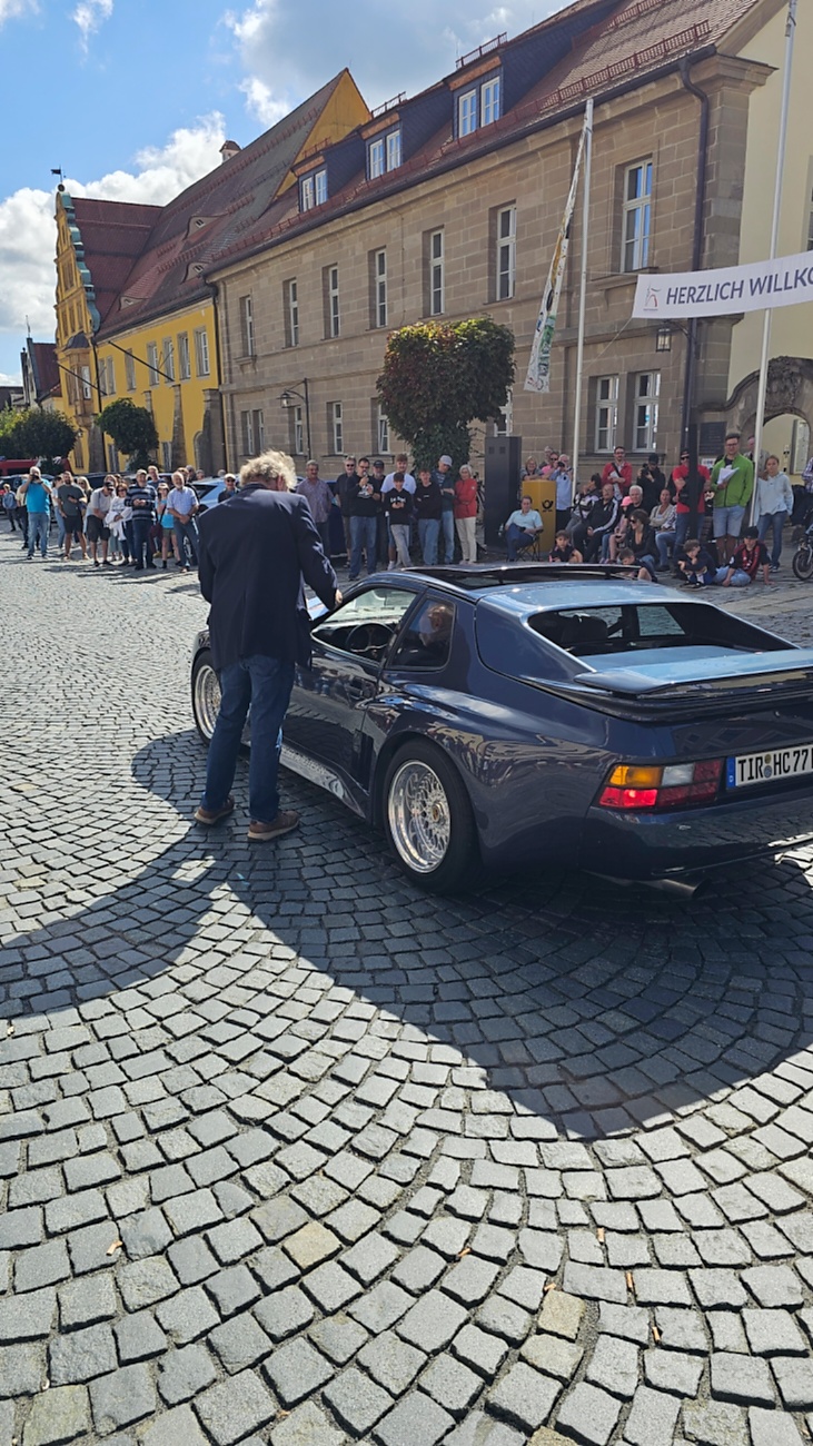 Jede Menge automobile Schätze auf dem Kemnather Stadtplatz

Ein echtes Paradies für Oldtimerfreunde gab es am Samstag beim großen Oldtimertreffen in Kemnath zu erleben. Ab 10 Uhr gehörte der wunderschöne historische Stadtplatz den automobilen Schätzen vergangener Jahrzehnte. Bei bestem Oldtimerwetter präsentierten sich die liebevoll gepflegten Fahrzeuge vor einer traumhaften Kulisse – und natürlich ließen sich das auch jede Menge Zuschauer nicht entgehen.

Dicht an dicht standen die Besucher entlang des Stadtplatzes, als ein Klassiker nach dem anderen zur Fahrzeugvorstellung vorfuhr. Dabei gab es nicht nur jede Menge Chrom, glänzenden Lack und den unverwechselbaren Klang alter Motoren zu bestaunen, sondern auch viel Wissenswertes zu hören.

Wie jedes Jahr hatte Elmar Högl das Mikrofon fest im Griff. Souverän und mit enormem Fachwissen stellte er die einzelnen Fahrzeuge vor, erzählte von Baujahren, Motorisierung und technischen Besonderheiten und hatte dabei immer wieder interessante Details zu den Oldtimern parat.

Und eigentlich ist Elmar Högl aus dem Kemnather Oldtimertreffen kaum wegzudenken. Er ist nicht nur die bekannte Stimme am Mikrofon, sondern zugleich Hauptorganisator und so etwas wie das „Herz“ des Treffens. Gemeinsam mit dem KEM-Verband und der Stadt Kemnath sorgt er dafür, dass die Freunde historischer Fahrzeuge Jahr für Jahr in Kemnath zusammenkommen.

Zur Fahrzeugvorstellung gehörte natürlich auch die Übergabe der Urkunden. Diese Aufgabe übernahm Hermann Schraml, unterstützt von Stefan Wöhrl.

Und besser hätte es an diesem Vormittag eigentlich kaum passen können: herrliches Wetter, ein voller Stadtplatz, viele begeisterte Zuschauer und mittendrin jede Menge automobile Zeitgeschichte auf zwei und vier Rädern.

Nach der Vorstellung blieb noch genügend Zeit, die Oldtimer aus nächster Nähe zu betrachten, mit den Besitzern ins Gespräch zu kommen und natürlich jede Menge Fotos zu machen.

Am Nachmittag wartete dann bereits der nächste Höhepunkt auf die Teilnehmer. Um 13:15 Uhr machten sich die historischen Fahrzeuge zur gemeinsamen Ausfahrt auf den Weg. Über Berndorf, Haidenaab und Weidenberg führte die Tour unter anderem nach Goldkronach, wo eine längere Rast eingelegt wurde, bevor es schließlich wieder zurück nach Kemnath ging.

Und jetzt viel Spaß beim Durchklicken durch unsere Bilder vom Kemnather Oldtimertreffen 2026!