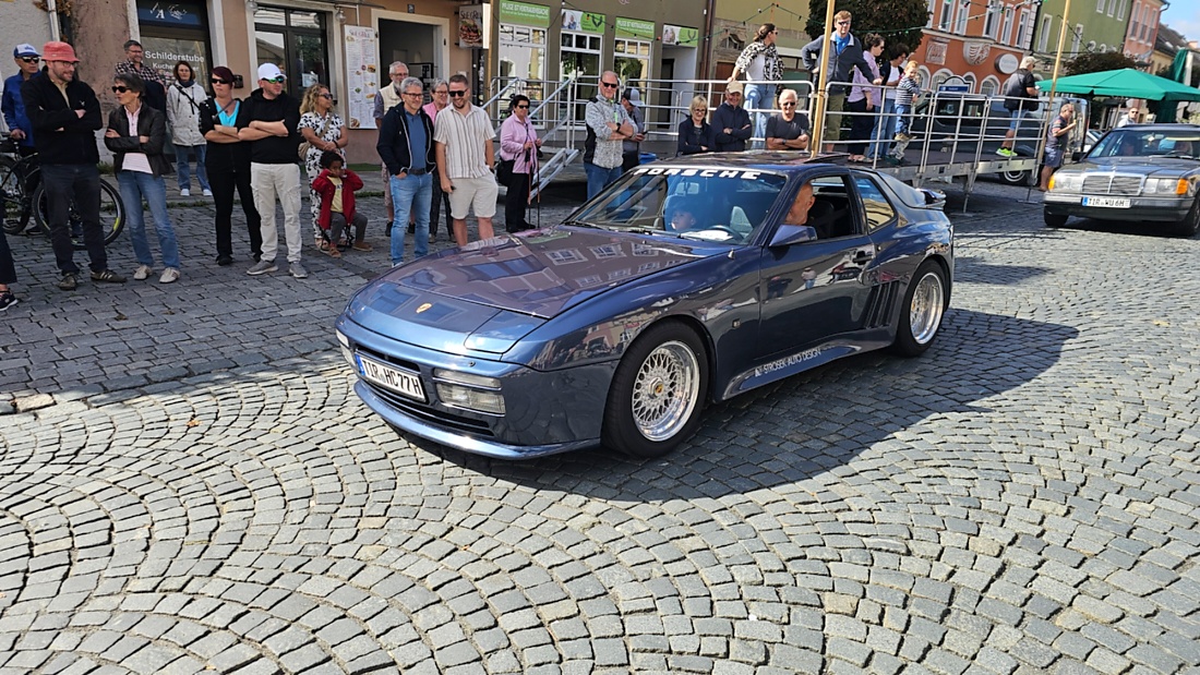 Jede Menge automobile Schätze auf dem Kemnather Stadtplatz

Ein echtes Paradies für Oldtimerfreunde gab es am Samstag beim großen Oldtimertreffen in Kemnath zu erleben. Ab 10 Uhr gehörte der wunderschöne historische Stadtplatz den automobilen Schätzen vergangener Jahrzehnte. Bei bestem Oldtimerwetter präsentierten sich die liebevoll gepflegten Fahrzeuge vor einer traumhaften Kulisse – und natürlich ließen sich das auch jede Menge Zuschauer nicht entgehen.

Dicht an dicht standen die Besucher entlang des Stadtplatzes, als ein Klassiker nach dem anderen zur Fahrzeugvorstellung vorfuhr. Dabei gab es nicht nur jede Menge Chrom, glänzenden Lack und den unverwechselbaren Klang alter Motoren zu bestaunen, sondern auch viel Wissenswertes zu hören.

Wie jedes Jahr hatte Elmar Högl das Mikrofon fest im Griff. Souverän und mit enormem Fachwissen stellte er die einzelnen Fahrzeuge vor, erzählte von Baujahren, Motorisierung und technischen Besonderheiten und hatte dabei immer wieder interessante Details zu den Oldtimern parat.

Und eigentlich ist Elmar Högl aus dem Kemnather Oldtimertreffen kaum wegzudenken. Er ist nicht nur die bekannte Stimme am Mikrofon, sondern zugleich Hauptorganisator und so etwas wie das „Herz“ des Treffens. Gemeinsam mit dem KEM-Verband und der Stadt Kemnath sorgt er dafür, dass die Freunde historischer Fahrzeuge Jahr für Jahr in Kemnath zusammenkommen.

Zur Fahrzeugvorstellung gehörte natürlich auch die Übergabe der Urkunden. Diese Aufgabe übernahm Hermann Schraml, unterstützt von Stefan Wöhrl.

Und besser hätte es an diesem Vormittag eigentlich kaum passen können: herrliches Wetter, ein voller Stadtplatz, viele begeisterte Zuschauer und mittendrin jede Menge automobile Zeitgeschichte auf zwei und vier Rädern.

Nach der Vorstellung blieb noch genügend Zeit, die Oldtimer aus nächster Nähe zu betrachten, mit den Besitzern ins Gespräch zu kommen und natürlich jede Menge Fotos zu machen.

Am Nachmittag wartete dann bereits der nächste Höhepunkt auf die Teilnehmer. Um 13:15 Uhr machten sich die historischen Fahrzeuge zur gemeinsamen Ausfahrt auf den Weg. Über Berndorf, Haidenaab und Weidenberg führte die Tour unter anderem nach Goldkronach, wo eine längere Rast eingelegt wurde, bevor es schließlich wieder zurück nach Kemnath ging.

Und jetzt viel Spaß beim Durchklicken durch unsere Bilder vom Kemnather Oldtimertreffen 2026!
