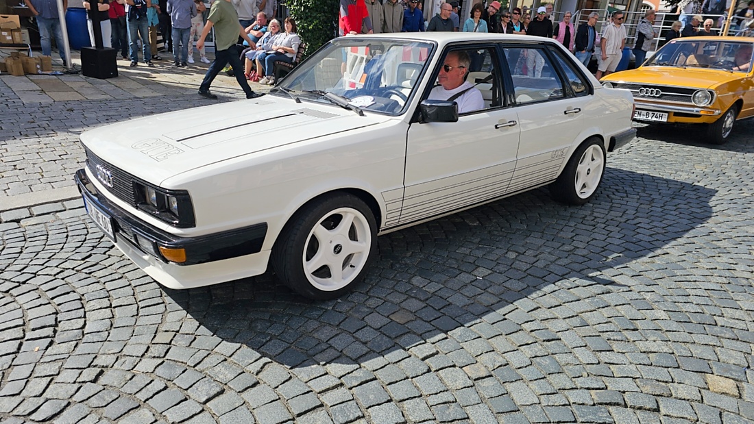 Jede Menge automobile Schätze auf dem Kemnather Stadtplatz

Ein echtes Paradies für Oldtimerfreunde gab es am Samstag beim großen Oldtimertreffen in Kemnath zu erleben. Ab 10 Uhr gehörte der wunderschöne historische Stadtplatz den automobilen Schätzen vergangener Jahrzehnte. Bei bestem Oldtimerwetter präsentierten sich die liebevoll gepflegten Fahrzeuge vor einer traumhaften Kulisse – und natürlich ließen sich das auch jede Menge Zuschauer nicht entgehen.

Dicht an dicht standen die Besucher entlang des Stadtplatzes, als ein Klassiker nach dem anderen zur Fahrzeugvorstellung vorfuhr. Dabei gab es nicht nur jede Menge Chrom, glänzenden Lack und den unverwechselbaren Klang alter Motoren zu bestaunen, sondern auch viel Wissenswertes zu hören.

Wie jedes Jahr hatte Elmar Högl das Mikrofon fest im Griff. Souverän und mit enormem Fachwissen stellte er die einzelnen Fahrzeuge vor, erzählte von Baujahren, Motorisierung und technischen Besonderheiten und hatte dabei immer wieder interessante Details zu den Oldtimern parat.

Und eigentlich ist Elmar Högl aus dem Kemnather Oldtimertreffen kaum wegzudenken. Er ist nicht nur die bekannte Stimme am Mikrofon, sondern zugleich Hauptorganisator und so etwas wie das „Herz“ des Treffens. Gemeinsam mit dem KEM-Verband und der Stadt Kemnath sorgt er dafür, dass die Freunde historischer Fahrzeuge Jahr für Jahr in Kemnath zusammenkommen.

Zur Fahrzeugvorstellung gehörte natürlich auch die Übergabe der Urkunden. Diese Aufgabe übernahm Hermann Schraml, unterstützt von Stefan Wöhrl.

Und besser hätte es an diesem Vormittag eigentlich kaum passen können: herrliches Wetter, ein voller Stadtplatz, viele begeisterte Zuschauer und mittendrin jede Menge automobile Zeitgeschichte auf zwei und vier Rädern.

Nach der Vorstellung blieb noch genügend Zeit, die Oldtimer aus nächster Nähe zu betrachten, mit den Besitzern ins Gespräch zu kommen und natürlich jede Menge Fotos zu machen.

Am Nachmittag wartete dann bereits der nächste Höhepunkt auf die Teilnehmer. Um 13:15 Uhr machten sich die historischen Fahrzeuge zur gemeinsamen Ausfahrt auf den Weg. Über Berndorf, Haidenaab und Weidenberg führte die Tour unter anderem nach Goldkronach, wo eine längere Rast eingelegt wurde, bevor es schließlich wieder zurück nach Kemnath ging.

Und jetzt viel Spaß beim Durchklicken durch unsere Bilder vom Kemnather Oldtimertreffen 2026!