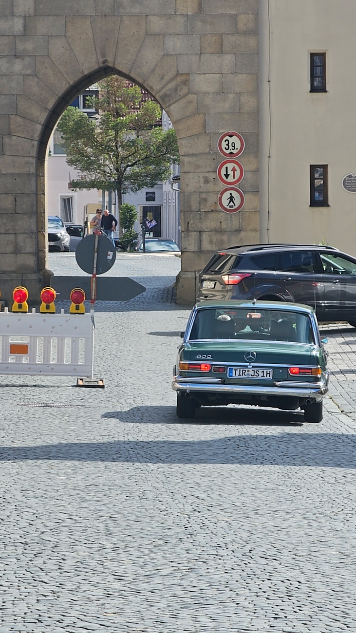 Jede Menge automobile Schätze auf dem Kemnather Stadtplatz

Ein echtes Paradies für Oldtimerfreunde gab es am Samstag beim großen Oldtimertreffen in Kemnath zu erleben. Ab 10 Uhr gehörte der wunderschöne historische Stadtplatz den automobilen Schätzen vergangener Jahrzehnte. Bei bestem Oldtimerwetter präsentierten sich die liebevoll gepflegten Fahrzeuge vor einer traumhaften Kulisse – und natürlich ließen sich das auch jede Menge Zuschauer nicht entgehen.

Dicht an dicht standen die Besucher entlang des Stadtplatzes, als ein Klassiker nach dem anderen zur Fahrzeugvorstellung vorfuhr. Dabei gab es nicht nur jede Menge Chrom, glänzenden Lack und den unverwechselbaren Klang alter Motoren zu bestaunen, sondern auch viel Wissenswertes zu hören.

Wie jedes Jahr hatte Elmar Högl das Mikrofon fest im Griff. Souverän und mit enormem Fachwissen stellte er die einzelnen Fahrzeuge vor, erzählte von Baujahren, Motorisierung und technischen Besonderheiten und hatte dabei immer wieder interessante Details zu den Oldtimern parat.

Und eigentlich ist Elmar Högl aus dem Kemnather Oldtimertreffen kaum wegzudenken. Er ist nicht nur die bekannte Stimme am Mikrofon, sondern zugleich Hauptorganisator und so etwas wie das „Herz“ des Treffens. Gemeinsam mit dem KEM-Verband und der Stadt Kemnath sorgt er dafür, dass die Freunde historischer Fahrzeuge Jahr für Jahr in Kemnath zusammenkommen.

Zur Fahrzeugvorstellung gehörte natürlich auch die Übergabe der Urkunden. Diese Aufgabe übernahm Hermann Schraml, unterstützt von Stefan Wöhrl.

Und besser hätte es an diesem Vormittag eigentlich kaum passen können: herrliches Wetter, ein voller Stadtplatz, viele begeisterte Zuschauer und mittendrin jede Menge automobile Zeitgeschichte auf zwei und vier Rädern.

Nach der Vorstellung blieb noch genügend Zeit, die Oldtimer aus nächster Nähe zu betrachten, mit den Besitzern ins Gespräch zu kommen und natürlich jede Menge Fotos zu machen.

Am Nachmittag wartete dann bereits der nächste Höhepunkt auf die Teilnehmer. Um 13:15 Uhr machten sich die historischen Fahrzeuge zur gemeinsamen Ausfahrt auf den Weg. Über Berndorf, Haidenaab und Weidenberg führte die Tour unter anderem nach Goldkronach, wo eine längere Rast eingelegt wurde, bevor es schließlich wieder zurück nach Kemnath ging.

Und jetzt viel Spaß beim Durchklicken durch unsere Bilder vom Kemnather Oldtimertreffen 2026!