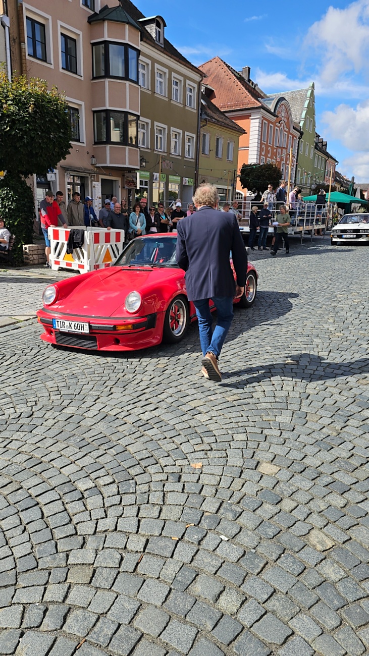 Jede Menge automobile Schätze auf dem Kemnather Stadtplatz

Ein echtes Paradies für Oldtimerfreunde gab es am Samstag beim großen Oldtimertreffen in Kemnath zu erleben. Ab 10 Uhr gehörte der wunderschöne historische Stadtplatz den automobilen Schätzen vergangener Jahrzehnte. Bei bestem Oldtimerwetter präsentierten sich die liebevoll gepflegten Fahrzeuge vor einer traumhaften Kulisse – und natürlich ließen sich das auch jede Menge Zuschauer nicht entgehen.

Dicht an dicht standen die Besucher entlang des Stadtplatzes, als ein Klassiker nach dem anderen zur Fahrzeugvorstellung vorfuhr. Dabei gab es nicht nur jede Menge Chrom, glänzenden Lack und den unverwechselbaren Klang alter Motoren zu bestaunen, sondern auch viel Wissenswertes zu hören.

Wie jedes Jahr hatte Elmar Högl das Mikrofon fest im Griff. Souverän und mit enormem Fachwissen stellte er die einzelnen Fahrzeuge vor, erzählte von Baujahren, Motorisierung und technischen Besonderheiten und hatte dabei immer wieder interessante Details zu den Oldtimern parat.

Und eigentlich ist Elmar Högl aus dem Kemnather Oldtimertreffen kaum wegzudenken. Er ist nicht nur die bekannte Stimme am Mikrofon, sondern zugleich Hauptorganisator und so etwas wie das „Herz“ des Treffens. Gemeinsam mit dem KEM-Verband und der Stadt Kemnath sorgt er dafür, dass die Freunde historischer Fahrzeuge Jahr für Jahr in Kemnath zusammenkommen.

Zur Fahrzeugvorstellung gehörte natürlich auch die Übergabe der Urkunden. Diese Aufgabe übernahm Hermann Schraml, unterstützt von Stefan Wöhrl.

Und besser hätte es an diesem Vormittag eigentlich kaum passen können: herrliches Wetter, ein voller Stadtplatz, viele begeisterte Zuschauer und mittendrin jede Menge automobile Zeitgeschichte auf zwei und vier Rädern.

Nach der Vorstellung blieb noch genügend Zeit, die Oldtimer aus nächster Nähe zu betrachten, mit den Besitzern ins Gespräch zu kommen und natürlich jede Menge Fotos zu machen.

Am Nachmittag wartete dann bereits der nächste Höhepunkt auf die Teilnehmer. Um 13:15 Uhr machten sich die historischen Fahrzeuge zur gemeinsamen Ausfahrt auf den Weg. Über Berndorf, Haidenaab und Weidenberg führte die Tour unter anderem nach Goldkronach, wo eine längere Rast eingelegt wurde, bevor es schließlich wieder zurück nach Kemnath ging.

Und jetzt viel Spaß beim Durchklicken durch unsere Bilder vom Kemnather Oldtimertreffen 2026!