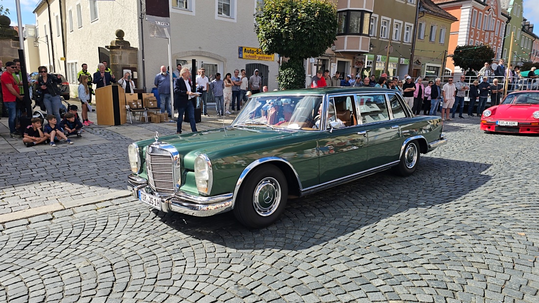 Jede Menge automobile Schätze auf dem Kemnather Stadtplatz

Ein echtes Paradies für Oldtimerfreunde gab es am Samstag beim großen Oldtimertreffen in Kemnath zu erleben. Ab 10 Uhr gehörte der wunderschöne historische Stadtplatz den automobilen Schätzen vergangener Jahrzehnte. Bei bestem Oldtimerwetter präsentierten sich die liebevoll gepflegten Fahrzeuge vor einer traumhaften Kulisse – und natürlich ließen sich das auch jede Menge Zuschauer nicht entgehen.

Dicht an dicht standen die Besucher entlang des Stadtplatzes, als ein Klassiker nach dem anderen zur Fahrzeugvorstellung vorfuhr. Dabei gab es nicht nur jede Menge Chrom, glänzenden Lack und den unverwechselbaren Klang alter Motoren zu bestaunen, sondern auch viel Wissenswertes zu hören.

Wie jedes Jahr hatte Elmar Högl das Mikrofon fest im Griff. Souverän und mit enormem Fachwissen stellte er die einzelnen Fahrzeuge vor, erzählte von Baujahren, Motorisierung und technischen Besonderheiten und hatte dabei immer wieder interessante Details zu den Oldtimern parat.

Und eigentlich ist Elmar Högl aus dem Kemnather Oldtimertreffen kaum wegzudenken. Er ist nicht nur die bekannte Stimme am Mikrofon, sondern zugleich Hauptorganisator und so etwas wie das „Herz“ des Treffens. Gemeinsam mit dem KEM-Verband und der Stadt Kemnath sorgt er dafür, dass die Freunde historischer Fahrzeuge Jahr für Jahr in Kemnath zusammenkommen.

Zur Fahrzeugvorstellung gehörte natürlich auch die Übergabe der Urkunden. Diese Aufgabe übernahm Hermann Schraml, unterstützt von Stefan Wöhrl.

Und besser hätte es an diesem Vormittag eigentlich kaum passen können: herrliches Wetter, ein voller Stadtplatz, viele begeisterte Zuschauer und mittendrin jede Menge automobile Zeitgeschichte auf zwei und vier Rädern.

Nach der Vorstellung blieb noch genügend Zeit, die Oldtimer aus nächster Nähe zu betrachten, mit den Besitzern ins Gespräch zu kommen und natürlich jede Menge Fotos zu machen.

Am Nachmittag wartete dann bereits der nächste Höhepunkt auf die Teilnehmer. Um 13:15 Uhr machten sich die historischen Fahrzeuge zur gemeinsamen Ausfahrt auf den Weg. Über Berndorf, Haidenaab und Weidenberg führte die Tour unter anderem nach Goldkronach, wo eine längere Rast eingelegt wurde, bevor es schließlich wieder zurück nach Kemnath ging.

Und jetzt viel Spaß beim Durchklicken durch unsere Bilder vom Kemnather Oldtimertreffen 2026!