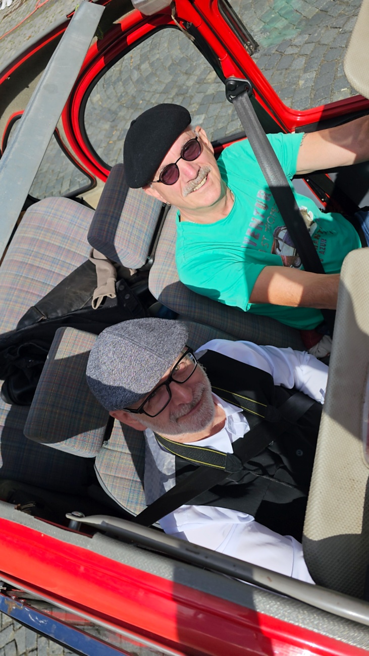 Jede Menge automobile Schätze auf dem Kemnather Stadtplatz

Ein echtes Paradies für Oldtimerfreunde gab es am Samstag beim großen Oldtimertreffen in Kemnath zu erleben. Ab 10 Uhr gehörte der wunderschöne historische Stadtplatz den automobilen Schätzen vergangener Jahrzehnte. Bei bestem Oldtimerwetter präsentierten sich die liebevoll gepflegten Fahrzeuge vor einer traumhaften Kulisse – und natürlich ließen sich das auch jede Menge Zuschauer nicht entgehen.

Dicht an dicht standen die Besucher entlang des Stadtplatzes, als ein Klassiker nach dem anderen zur Fahrzeugvorstellung vorfuhr. Dabei gab es nicht nur jede Menge Chrom, glänzenden Lack und den unverwechselbaren Klang alter Motoren zu bestaunen, sondern auch viel Wissenswertes zu hören.

Wie jedes Jahr hatte Elmar Högl das Mikrofon fest im Griff. Souverän und mit enormem Fachwissen stellte er die einzelnen Fahrzeuge vor, erzählte von Baujahren, Motorisierung und technischen Besonderheiten und hatte dabei immer wieder interessante Details zu den Oldtimern parat.

Und eigentlich ist Elmar Högl aus dem Kemnather Oldtimertreffen kaum wegzudenken. Er ist nicht nur die bekannte Stimme am Mikrofon, sondern zugleich Hauptorganisator und so etwas wie das „Herz“ des Treffens. Gemeinsam mit dem KEM-Verband und der Stadt Kemnath sorgt er dafür, dass die Freunde historischer Fahrzeuge Jahr für Jahr in Kemnath zusammenkommen.

Zur Fahrzeugvorstellung gehörte natürlich auch die Übergabe der Urkunden. Diese Aufgabe übernahm Hermann Schraml, unterstützt von Stefan Wöhrl.

Und besser hätte es an diesem Vormittag eigentlich kaum passen können: herrliches Wetter, ein voller Stadtplatz, viele begeisterte Zuschauer und mittendrin jede Menge automobile Zeitgeschichte auf zwei und vier Rädern.

Nach der Vorstellung blieb noch genügend Zeit, die Oldtimer aus nächster Nähe zu betrachten, mit den Besitzern ins Gespräch zu kommen und natürlich jede Menge Fotos zu machen.

Am Nachmittag wartete dann bereits der nächste Höhepunkt auf die Teilnehmer. Um 13:15 Uhr machten sich die historischen Fahrzeuge zur gemeinsamen Ausfahrt auf den Weg. Über Berndorf, Haidenaab und Weidenberg führte die Tour unter anderem nach Goldkronach, wo eine längere Rast eingelegt wurde, bevor es schließlich wieder zurück nach Kemnath ging.

Und jetzt viel Spaß beim Durchklicken durch unsere Bilder vom Kemnather Oldtimertreffen 2026!