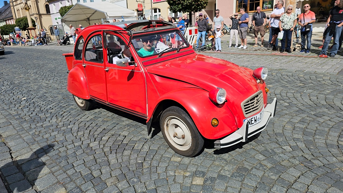 Jede Menge automobile Schätze auf dem Kemnather Stadtplatz

Ein echtes Paradies für Oldtimerfreunde gab es am Samstag beim großen Oldtimertreffen in Kemnath zu erleben. Ab 10 Uhr gehörte der wunderschöne historische Stadtplatz den automobilen Schätzen vergangener Jahrzehnte. Bei bestem Oldtimerwetter präsentierten sich die liebevoll gepflegten Fahrzeuge vor einer traumhaften Kulisse – und natürlich ließen sich das auch jede Menge Zuschauer nicht entgehen.

Dicht an dicht standen die Besucher entlang des Stadtplatzes, als ein Klassiker nach dem anderen zur Fahrzeugvorstellung vorfuhr. Dabei gab es nicht nur jede Menge Chrom, glänzenden Lack und den unverwechselbaren Klang alter Motoren zu bestaunen, sondern auch viel Wissenswertes zu hören.

Wie jedes Jahr hatte Elmar Högl das Mikrofon fest im Griff. Souverän und mit enormem Fachwissen stellte er die einzelnen Fahrzeuge vor, erzählte von Baujahren, Motorisierung und technischen Besonderheiten und hatte dabei immer wieder interessante Details zu den Oldtimern parat.

Und eigentlich ist Elmar Högl aus dem Kemnather Oldtimertreffen kaum wegzudenken. Er ist nicht nur die bekannte Stimme am Mikrofon, sondern zugleich Hauptorganisator und so etwas wie das „Herz“ des Treffens. Gemeinsam mit dem KEM-Verband und der Stadt Kemnath sorgt er dafür, dass die Freunde historischer Fahrzeuge Jahr für Jahr in Kemnath zusammenkommen.

Zur Fahrzeugvorstellung gehörte natürlich auch die Übergabe der Urkunden. Diese Aufgabe übernahm Hermann Schraml, unterstützt von Stefan Wöhrl.

Und besser hätte es an diesem Vormittag eigentlich kaum passen können: herrliches Wetter, ein voller Stadtplatz, viele begeisterte Zuschauer und mittendrin jede Menge automobile Zeitgeschichte auf zwei und vier Rädern.

Nach der Vorstellung blieb noch genügend Zeit, die Oldtimer aus nächster Nähe zu betrachten, mit den Besitzern ins Gespräch zu kommen und natürlich jede Menge Fotos zu machen.

Am Nachmittag wartete dann bereits der nächste Höhepunkt auf die Teilnehmer. Um 13:15 Uhr machten sich die historischen Fahrzeuge zur gemeinsamen Ausfahrt auf den Weg. Über Berndorf, Haidenaab und Weidenberg führte die Tour unter anderem nach Goldkronach, wo eine längere Rast eingelegt wurde, bevor es schließlich wieder zurück nach Kemnath ging.

Und jetzt viel Spaß beim Durchklicken durch unsere Bilder vom Kemnather Oldtimertreffen 2026!