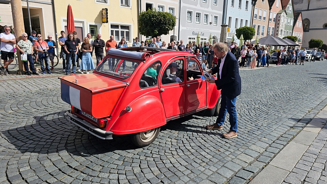 Jede Menge automobile Schätze auf dem Kemnather Stadtplatz

Ein echtes Paradies für Oldtimerfreunde gab es am Samstag beim großen Oldtimertreffen in Kemnath zu erleben. Ab 10 Uhr gehörte der wunderschöne historische Stadtplatz den automobilen Schätzen vergangener Jahrzehnte. Bei bestem Oldtimerwetter präsentierten sich die liebevoll gepflegten Fahrzeuge vor einer traumhaften Kulisse – und natürlich ließen sich das auch jede Menge Zuschauer nicht entgehen.

Dicht an dicht standen die Besucher entlang des Stadtplatzes, als ein Klassiker nach dem anderen zur Fahrzeugvorstellung vorfuhr. Dabei gab es nicht nur jede Menge Chrom, glänzenden Lack und den unverwechselbaren Klang alter Motoren zu bestaunen, sondern auch viel Wissenswertes zu hören.

Wie jedes Jahr hatte Elmar Högl das Mikrofon fest im Griff. Souverän und mit enormem Fachwissen stellte er die einzelnen Fahrzeuge vor, erzählte von Baujahren, Motorisierung und technischen Besonderheiten und hatte dabei immer wieder interessante Details zu den Oldtimern parat.

Und eigentlich ist Elmar Högl aus dem Kemnather Oldtimertreffen kaum wegzudenken. Er ist nicht nur die bekannte Stimme am Mikrofon, sondern zugleich Hauptorganisator und so etwas wie das „Herz“ des Treffens. Gemeinsam mit dem KEM-Verband und der Stadt Kemnath sorgt er dafür, dass die Freunde historischer Fahrzeuge Jahr für Jahr in Kemnath zusammenkommen.

Zur Fahrzeugvorstellung gehörte natürlich auch die Übergabe der Urkunden. Diese Aufgabe übernahm Hermann Schraml, unterstützt von Stefan Wöhrl.

Und besser hätte es an diesem Vormittag eigentlich kaum passen können: herrliches Wetter, ein voller Stadtplatz, viele begeisterte Zuschauer und mittendrin jede Menge automobile Zeitgeschichte auf zwei und vier Rädern.

Nach der Vorstellung blieb noch genügend Zeit, die Oldtimer aus nächster Nähe zu betrachten, mit den Besitzern ins Gespräch zu kommen und natürlich jede Menge Fotos zu machen.

Am Nachmittag wartete dann bereits der nächste Höhepunkt auf die Teilnehmer. Um 13:15 Uhr machten sich die historischen Fahrzeuge zur gemeinsamen Ausfahrt auf den Weg. Über Berndorf, Haidenaab und Weidenberg führte die Tour unter anderem nach Goldkronach, wo eine längere Rast eingelegt wurde, bevor es schließlich wieder zurück nach Kemnath ging.

Und jetzt viel Spaß beim Durchklicken durch unsere Bilder vom Kemnather Oldtimertreffen 2026!