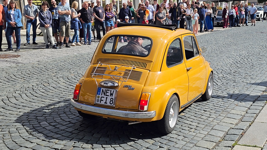 Jede Menge automobile Schätze auf dem Kemnather Stadtplatz

Ein echtes Paradies für Oldtimerfreunde gab es am Samstag beim großen Oldtimertreffen in Kemnath zu erleben. Ab 10 Uhr gehörte der wunderschöne historische Stadtplatz den automobilen Schätzen vergangener Jahrzehnte. Bei bestem Oldtimerwetter präsentierten sich die liebevoll gepflegten Fahrzeuge vor einer traumhaften Kulisse – und natürlich ließen sich das auch jede Menge Zuschauer nicht entgehen.

Dicht an dicht standen die Besucher entlang des Stadtplatzes, als ein Klassiker nach dem anderen zur Fahrzeugvorstellung vorfuhr. Dabei gab es nicht nur jede Menge Chrom, glänzenden Lack und den unverwechselbaren Klang alter Motoren zu bestaunen, sondern auch viel Wissenswertes zu hören.

Wie jedes Jahr hatte Elmar Högl das Mikrofon fest im Griff. Souverän und mit enormem Fachwissen stellte er die einzelnen Fahrzeuge vor, erzählte von Baujahren, Motorisierung und technischen Besonderheiten und hatte dabei immer wieder interessante Details zu den Oldtimern parat.

Und eigentlich ist Elmar Högl aus dem Kemnather Oldtimertreffen kaum wegzudenken. Er ist nicht nur die bekannte Stimme am Mikrofon, sondern zugleich Hauptorganisator und so etwas wie das „Herz“ des Treffens. Gemeinsam mit dem KEM-Verband und der Stadt Kemnath sorgt er dafür, dass die Freunde historischer Fahrzeuge Jahr für Jahr in Kemnath zusammenkommen.

Zur Fahrzeugvorstellung gehörte natürlich auch die Übergabe der Urkunden. Diese Aufgabe übernahm Hermann Schraml, unterstützt von Stefan Wöhrl.

Und besser hätte es an diesem Vormittag eigentlich kaum passen können: herrliches Wetter, ein voller Stadtplatz, viele begeisterte Zuschauer und mittendrin jede Menge automobile Zeitgeschichte auf zwei und vier Rädern.

Nach der Vorstellung blieb noch genügend Zeit, die Oldtimer aus nächster Nähe zu betrachten, mit den Besitzern ins Gespräch zu kommen und natürlich jede Menge Fotos zu machen.

Am Nachmittag wartete dann bereits der nächste Höhepunkt auf die Teilnehmer. Um 13:15 Uhr machten sich die historischen Fahrzeuge zur gemeinsamen Ausfahrt auf den Weg. Über Berndorf, Haidenaab und Weidenberg führte die Tour unter anderem nach Goldkronach, wo eine längere Rast eingelegt wurde, bevor es schließlich wieder zurück nach Kemnath ging.

Und jetzt viel Spaß beim Durchklicken durch unsere Bilder vom Kemnather Oldtimertreffen 2026!