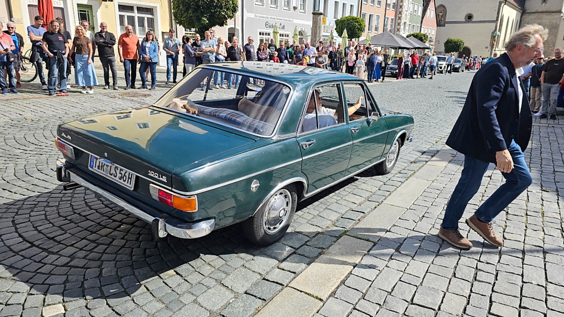 Jede Menge automobile Schätze auf dem Kemnather Stadtplatz

Ein echtes Paradies für Oldtimerfreunde gab es am Samstag beim großen Oldtimertreffen in Kemnath zu erleben. Ab 10 Uhr gehörte der wunderschöne historische Stadtplatz den automobilen Schätzen vergangener Jahrzehnte. Bei bestem Oldtimerwetter präsentierten sich die liebevoll gepflegten Fahrzeuge vor einer traumhaften Kulisse – und natürlich ließen sich das auch jede Menge Zuschauer nicht entgehen.

Dicht an dicht standen die Besucher entlang des Stadtplatzes, als ein Klassiker nach dem anderen zur Fahrzeugvorstellung vorfuhr. Dabei gab es nicht nur jede Menge Chrom, glänzenden Lack und den unverwechselbaren Klang alter Motoren zu bestaunen, sondern auch viel Wissenswertes zu hören.

Wie jedes Jahr hatte Elmar Högl das Mikrofon fest im Griff. Souverän und mit enormem Fachwissen stellte er die einzelnen Fahrzeuge vor, erzählte von Baujahren, Motorisierung und technischen Besonderheiten und hatte dabei immer wieder interessante Details zu den Oldtimern parat.

Und eigentlich ist Elmar Högl aus dem Kemnather Oldtimertreffen kaum wegzudenken. Er ist nicht nur die bekannte Stimme am Mikrofon, sondern zugleich Hauptorganisator und so etwas wie das „Herz“ des Treffens. Gemeinsam mit dem KEM-Verband und der Stadt Kemnath sorgt er dafür, dass die Freunde historischer Fahrzeuge Jahr für Jahr in Kemnath zusammenkommen.

Zur Fahrzeugvorstellung gehörte natürlich auch die Übergabe der Urkunden. Diese Aufgabe übernahm Hermann Schraml, unterstützt von Stefan Wöhrl.

Und besser hätte es an diesem Vormittag eigentlich kaum passen können: herrliches Wetter, ein voller Stadtplatz, viele begeisterte Zuschauer und mittendrin jede Menge automobile Zeitgeschichte auf zwei und vier Rädern.

Nach der Vorstellung blieb noch genügend Zeit, die Oldtimer aus nächster Nähe zu betrachten, mit den Besitzern ins Gespräch zu kommen und natürlich jede Menge Fotos zu machen.

Am Nachmittag wartete dann bereits der nächste Höhepunkt auf die Teilnehmer. Um 13:15 Uhr machten sich die historischen Fahrzeuge zur gemeinsamen Ausfahrt auf den Weg. Über Berndorf, Haidenaab und Weidenberg führte die Tour unter anderem nach Goldkronach, wo eine längere Rast eingelegt wurde, bevor es schließlich wieder zurück nach Kemnath ging.

Und jetzt viel Spaß beim Durchklicken durch unsere Bilder vom Kemnather Oldtimertreffen 2026!