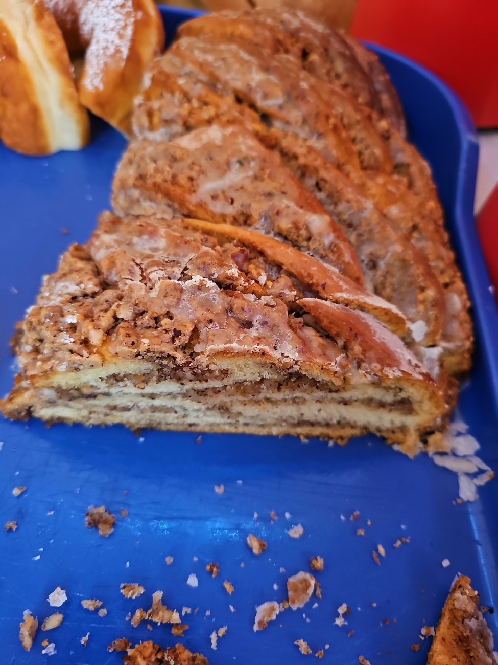 Ein saftiger Nusszopf aus lockerem Hefeteig, gefüllt mit Nussmasse und Zuckerguss, kunstvoll verflochten.