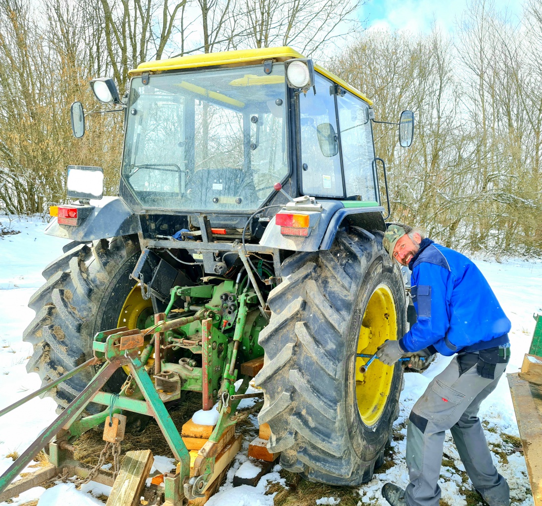 Foto: Jennifer Müller - Bulldog-Reifen-Wechsel mitten auf der Wiese... H. Köstler vom Bio-Bauernhof in Hermannsreuth bei Ebnath montiert hier das bereits reparierte Rad wieder auf die Nabe.<br />
<br />
B 