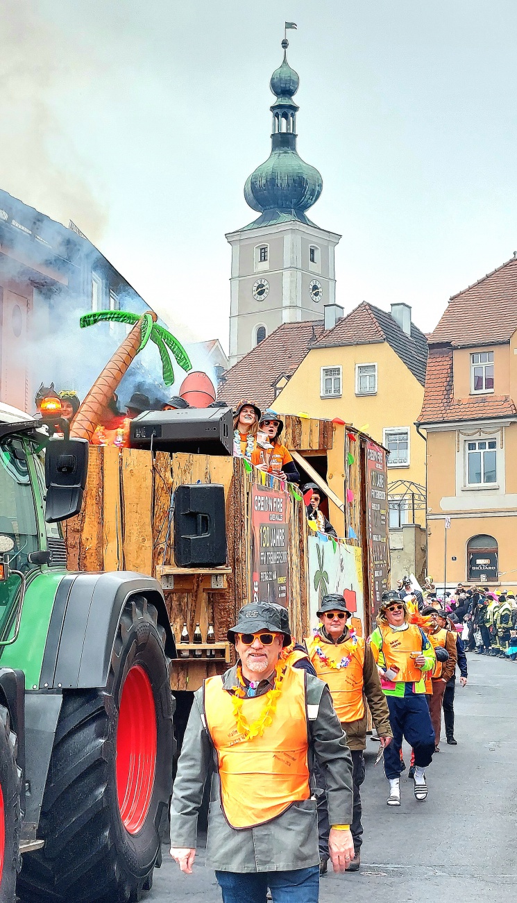 Das Bild zeigt den Faschingsumzug in Pressath 2026 mit ausgelassener Stimmung und vielen feiernden Menschen.
Auf einem festlich geschmückten Wagen feiern junge Leute bei Musik und guter Laune.
Zahlreiche Besucher in bunten Kostümen säumen die Straßen und genießen das Spektakel.
Seifenblasen, Farben und fröhliche Gesichter prägen das lebendige Bild des Faschings.
Der Fasching in Pressath verbindet Gemeinschaft, Tradition und pure Lebensfreude.