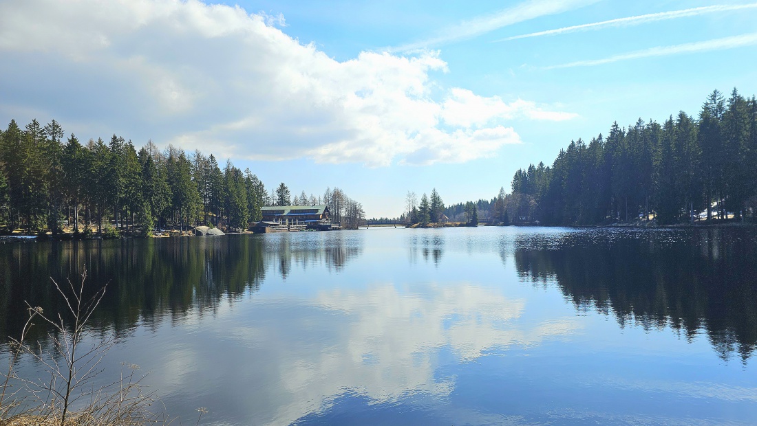 Der Himmel spiegelt sich in der ruhenden Wasseroberfläche des Fichtelsees.