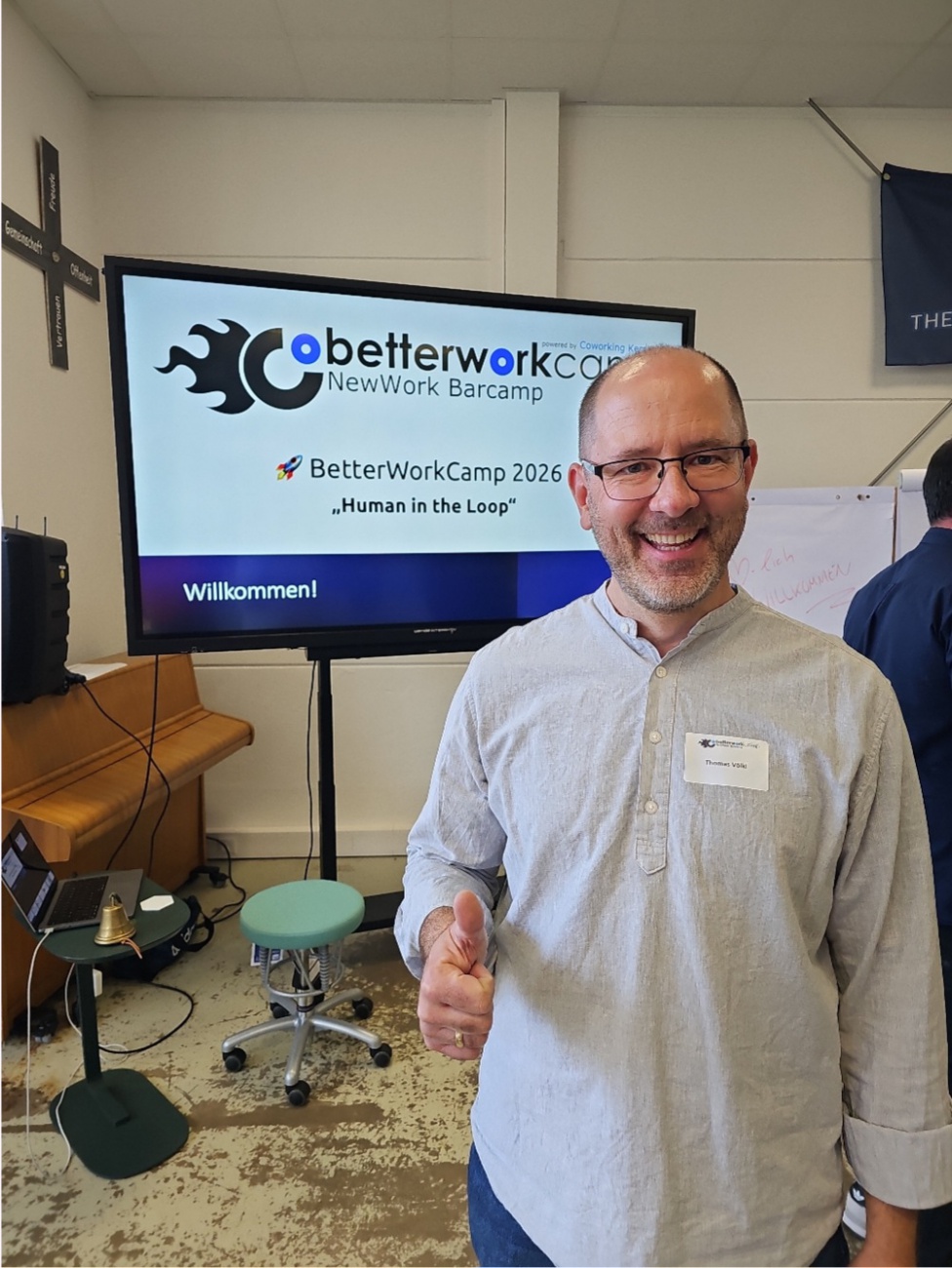 Ein sympathisches Lächeln und ein überzeugtes Daumenhoch sind das strahlende Signal eines Moments, in dem Gemeinschaft und Zukunftsfragen zusammentreffen: 

Unter dem Motto ..Human in the Loop“ lädt das BetterWorkCamp 2026 als New-Work-Barcamp zum offenen Austausch über die Rolle des Menschen im Zeitalter von Künstlicher Intelligenz ein. 
Gastgeber Coworking Kem­nath zeigt zum fünften Mal, dass Innovationskraft auch mitten in der Nordoberpfalz wächst – und das Thema KI längst nicht mehr nur in den Metropolen verhandelt wird. 
Die Tickets waren restlos vergriffen, selbst regionale Unternehmen wie Raiffeisenbank, Sparkasse Nördliche Oberpfalz und weitere Partner tragen die Veranstaltung mit, um Raum für Dialog und Ideen zu bieten. Hier entsteht Zukunft nicht abstrakt, sondern ehrlich und auf Augenhöhe.

Person im Bild: Thomas Völkl

Artikel mit KI-Unterstützung