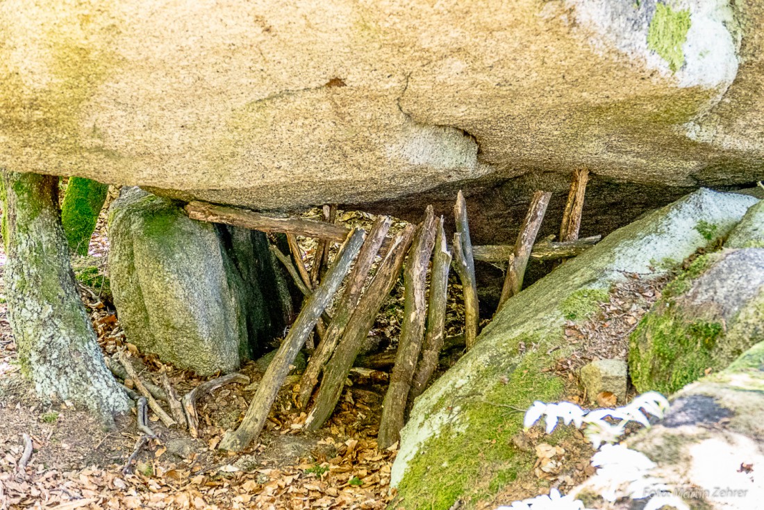 Foto: Martin Zehrer - Wohnt hier jemand im Steinwald unterm Stein? Irgendjemand hat hier Holzstämmchen unter dem Fels angeordnet. 