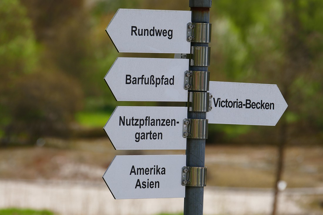 Foto: Martin Zehrer - Wegweiser in die verschiedenen Zonen im Ökologisch-Botanischen Garten in Bayreuth. Ausspannen in der Frühlingssonne. Die Blätter rauschen im Wind, Vögel zwitschern um die 